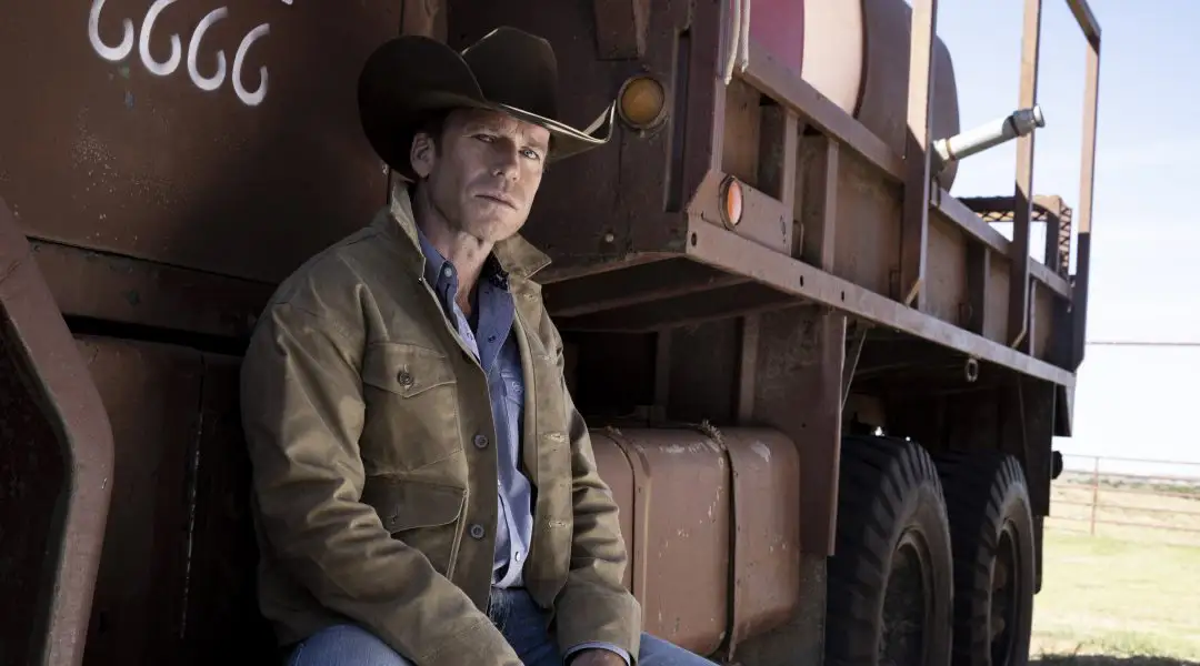 Taylor Sheridan sitting on the side of a Four Sixes truck.